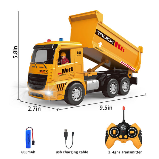 Toy dump truck with remote control, battery, and charging cable on a white background