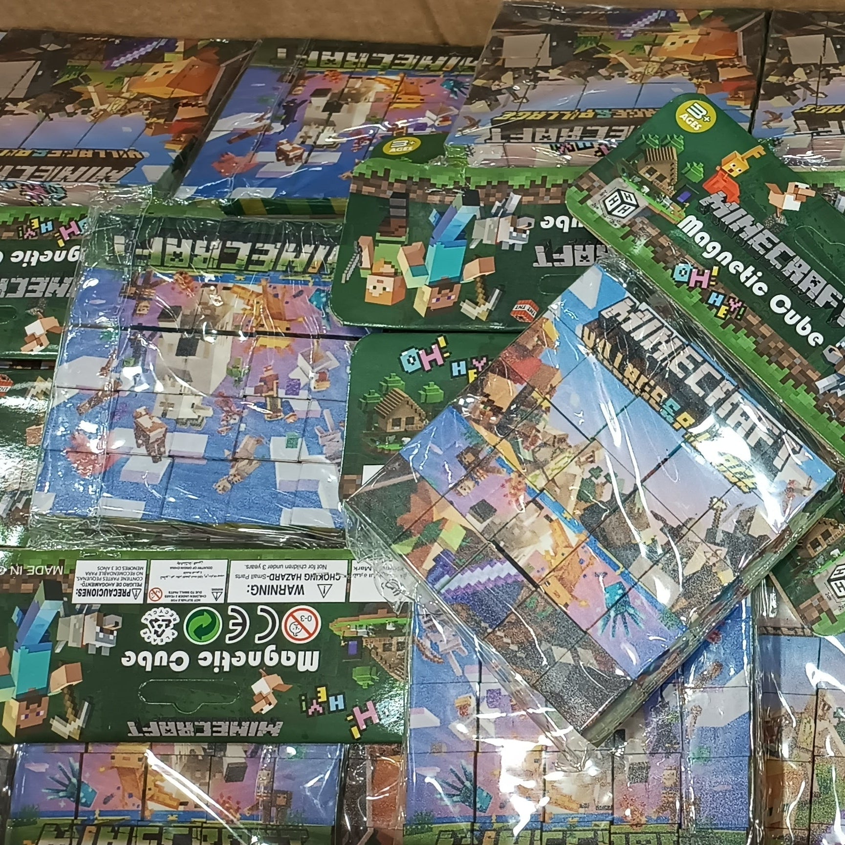 A bulk lot of Minecraft magnetic cube toy sets in their original green packaging, stacked inside a cardboard box.