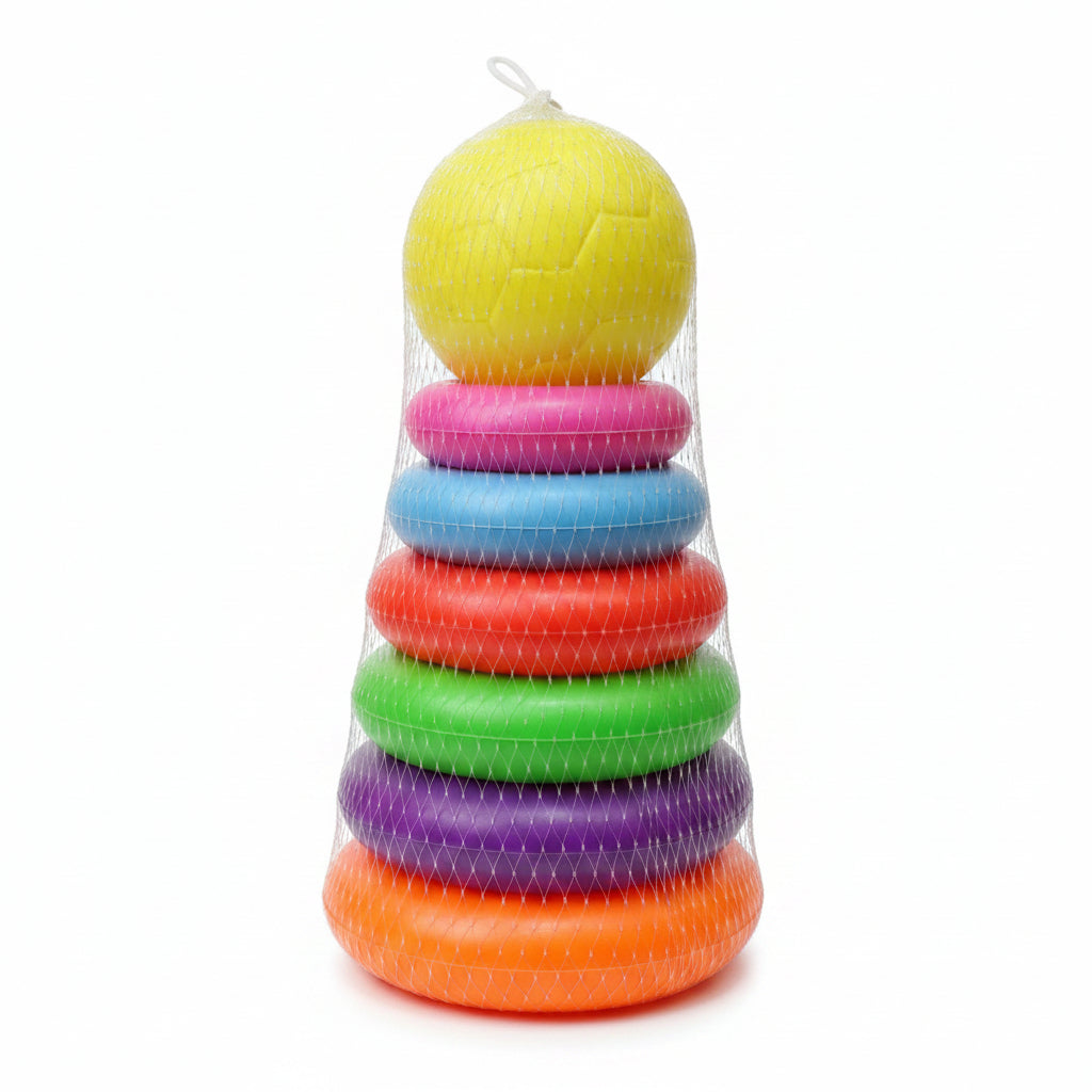 A stack of colorful plastic stacking rings with a yellow soccer ball on top, wrapped in white mesh packaging, set against a blurry store background.